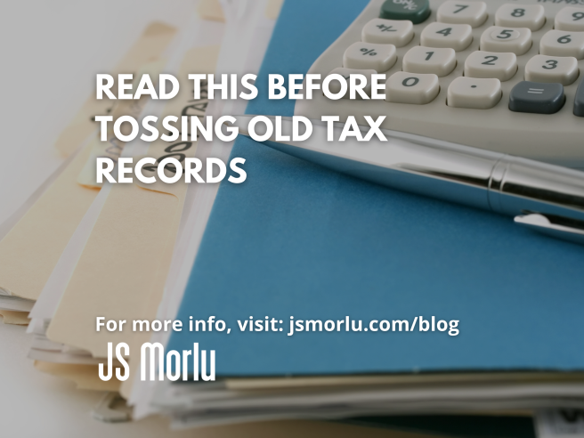 A messy desk with a stack of papers and a calculator on top - tax records.