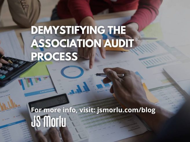 Two people, engaged in a deep discussion, lean over a table scattered with papers, charts, and graphs - audit association.