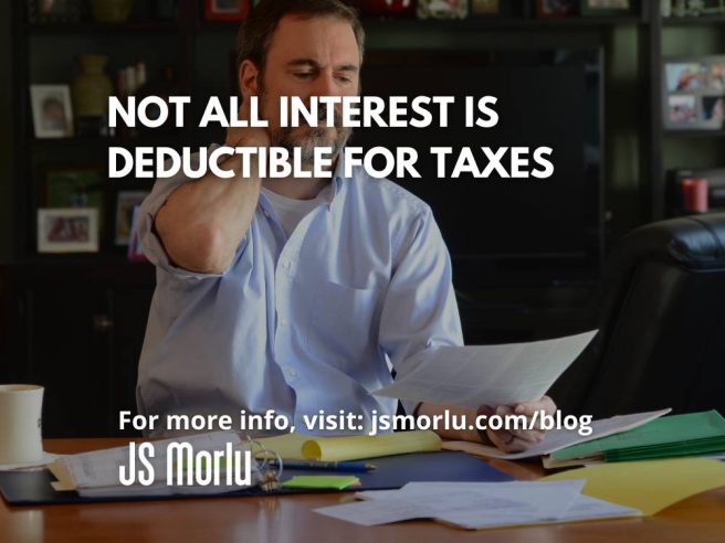 An image of a man sitting at a table, surrounded by tax documents, looking frustrated as he attempts to complete his taxes - Deductible for tax