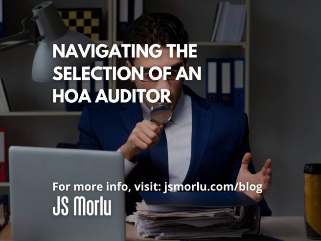 A man in a suit, his eyes wide with shock, clutches round glasses in his hand. His cluttered desk reflects his disarray: an open laptop, a forgotten cup of tea, and towering piles of files - hoa auditor.